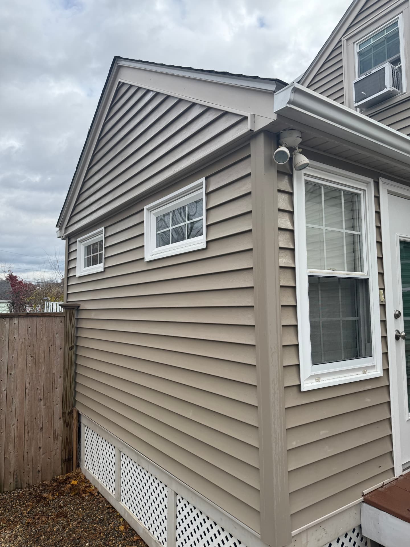 Freshly washed vinyl siding on a two-story home with clean trim and gutters