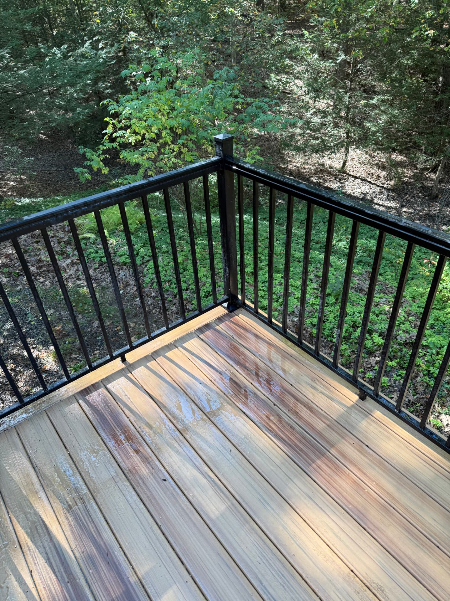The same wood deck clean and bright showing natural wood grain after pressure washing