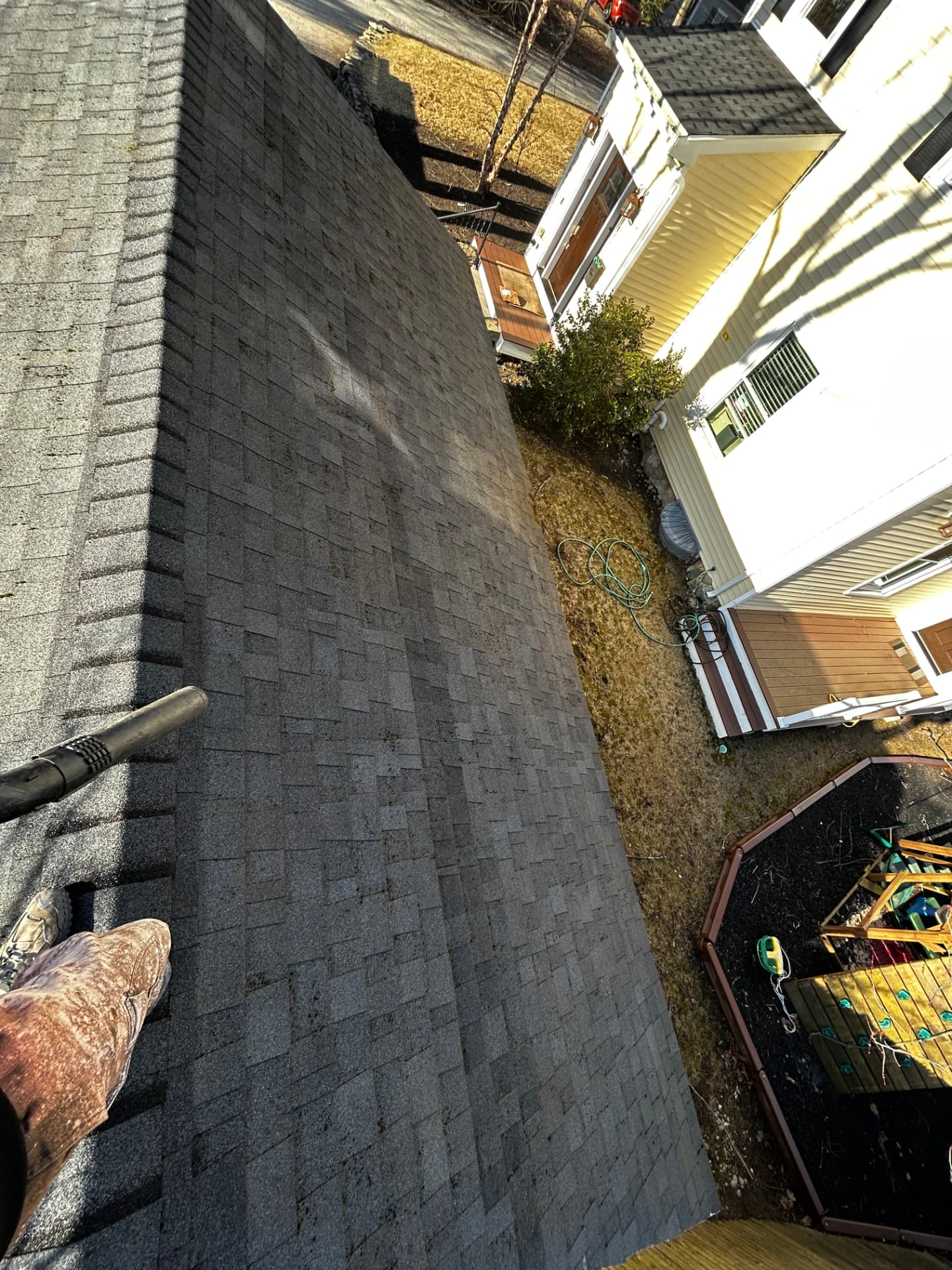 The same roof slope clean and uniform gray after professional roof washing