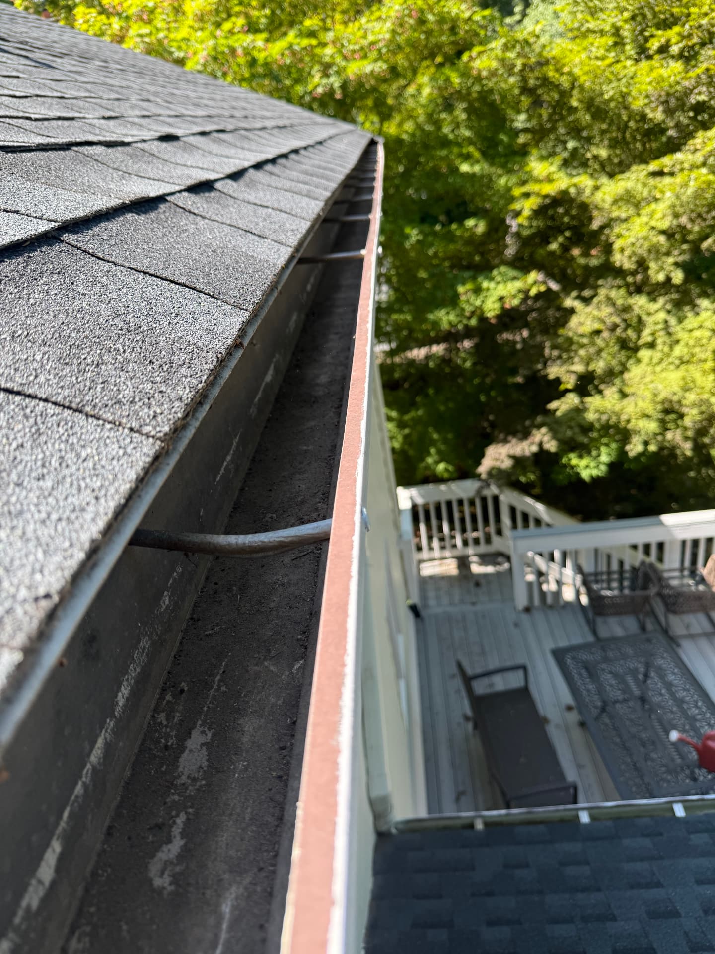 Gutter filled with dark sludge and sediment before cleaning