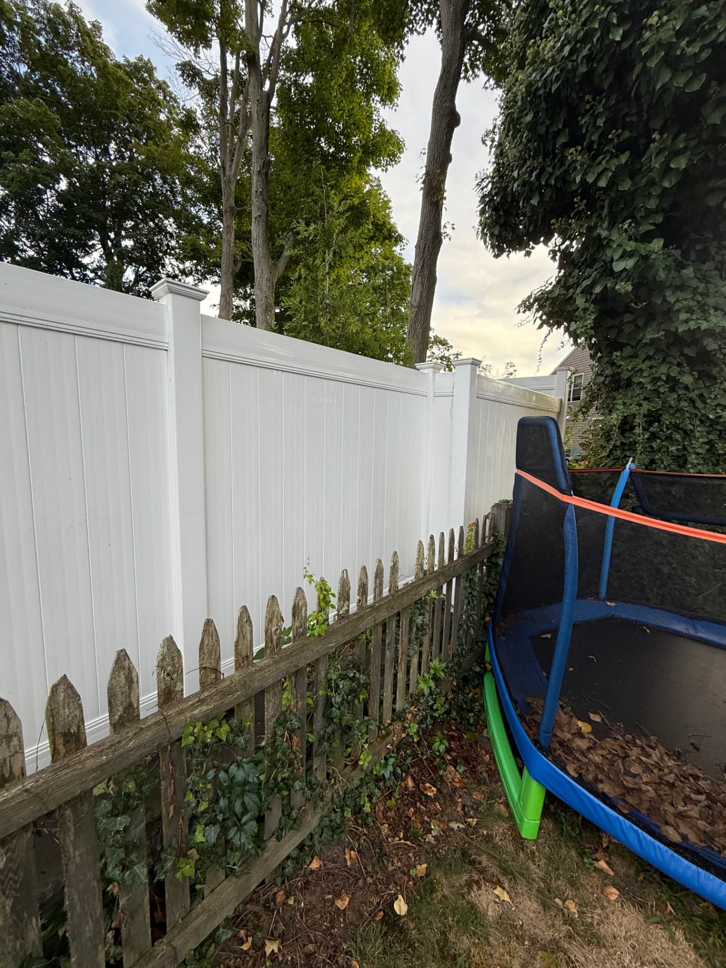 The same vinyl fence bright white and clean after pressure washing